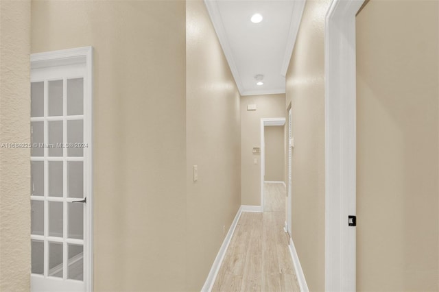 corridor with ornamental molding and light wood-type flooring