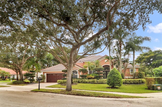 mediterranean / spanish home with a front lawn and a garage