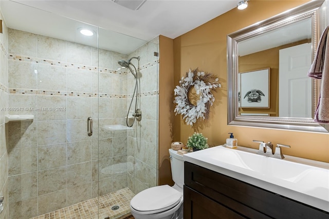 bathroom with vanity, a shower with shower door, and toilet