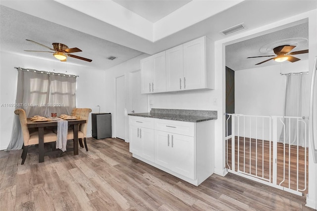 kitchen with white cabinetry, light hardwood / wood-style floors, and a textured ceiling