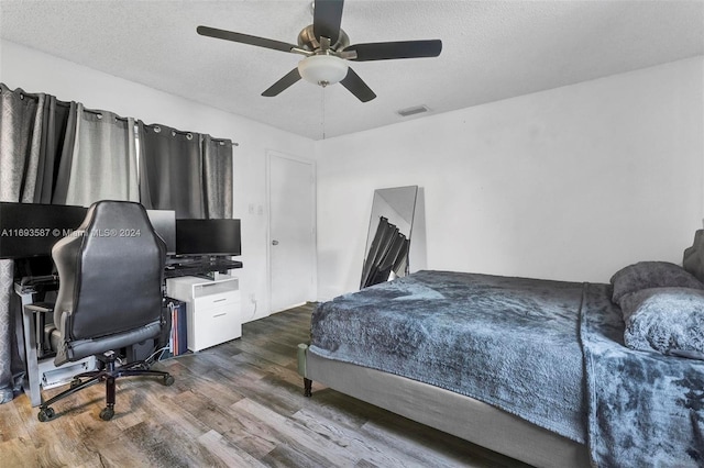 bedroom with a textured ceiling, dark hardwood / wood-style flooring, and ceiling fan