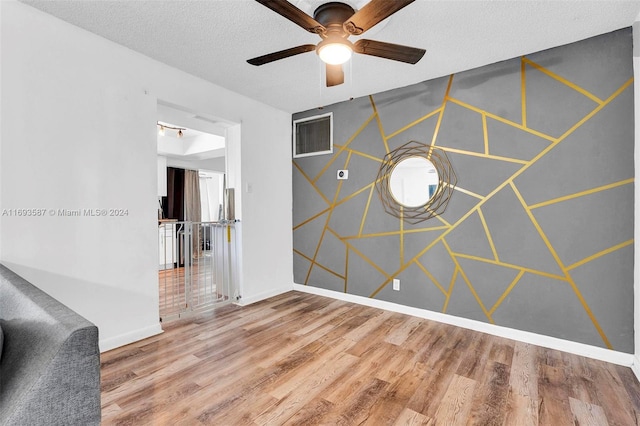 unfurnished room featuring a textured ceiling, hardwood / wood-style flooring, and ceiling fan