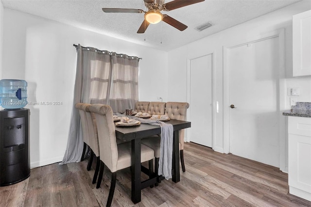 dining room with hardwood / wood-style floors, a textured ceiling, and ceiling fan