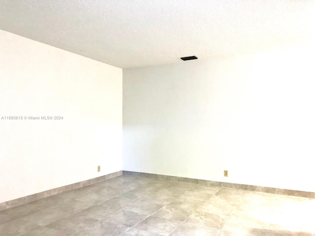 spare room with a textured ceiling