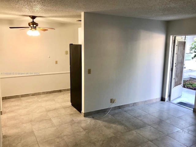 unfurnished room with ceiling fan and a textured ceiling