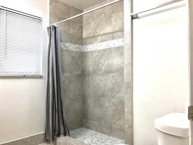 bathroom featuring curtained shower and toilet