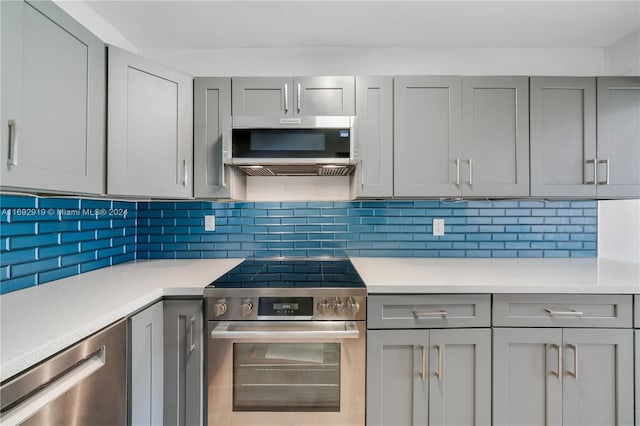 kitchen featuring backsplash, stainless steel appliances, and gray cabinets