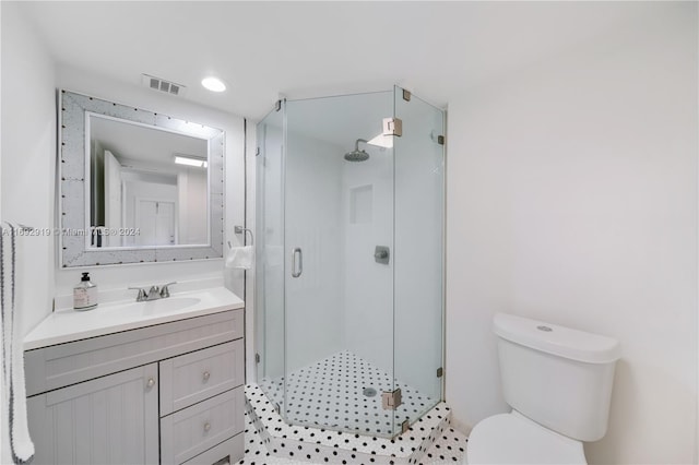 bathroom featuring vanity, toilet, and a shower with door