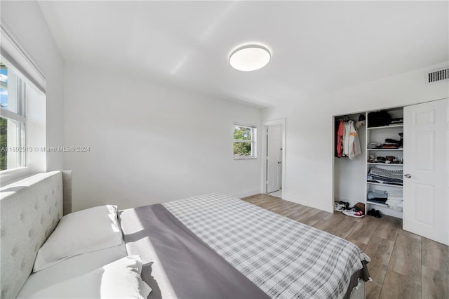 bedroom with light hardwood / wood-style floors and a closet