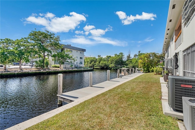 dock area with a water view, a yard, and central AC unit