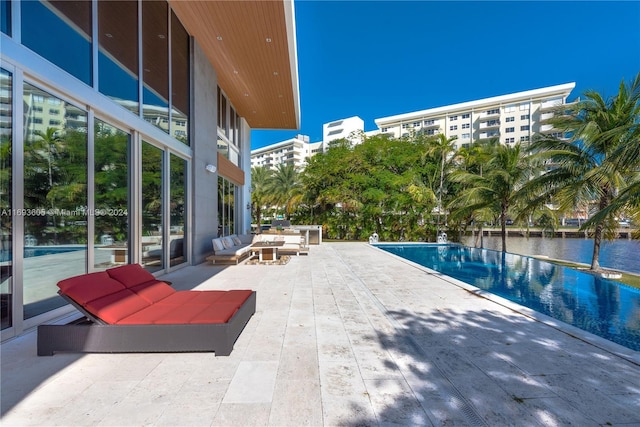 view of swimming pool featuring a water view and a patio