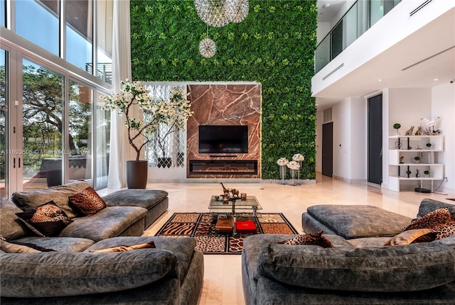 living room featuring a towering ceiling and a high end fireplace