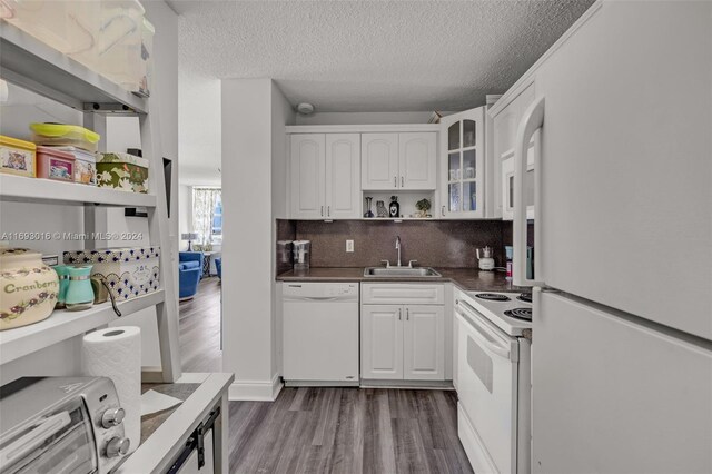 kitchen featuring white appliances, white cabinets, sink, dark hardwood / wood-style floors, and a textured ceiling