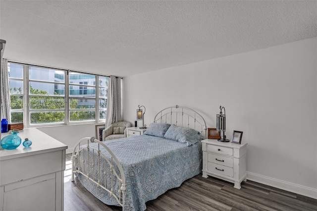 bedroom with a textured ceiling and dark hardwood / wood-style floors