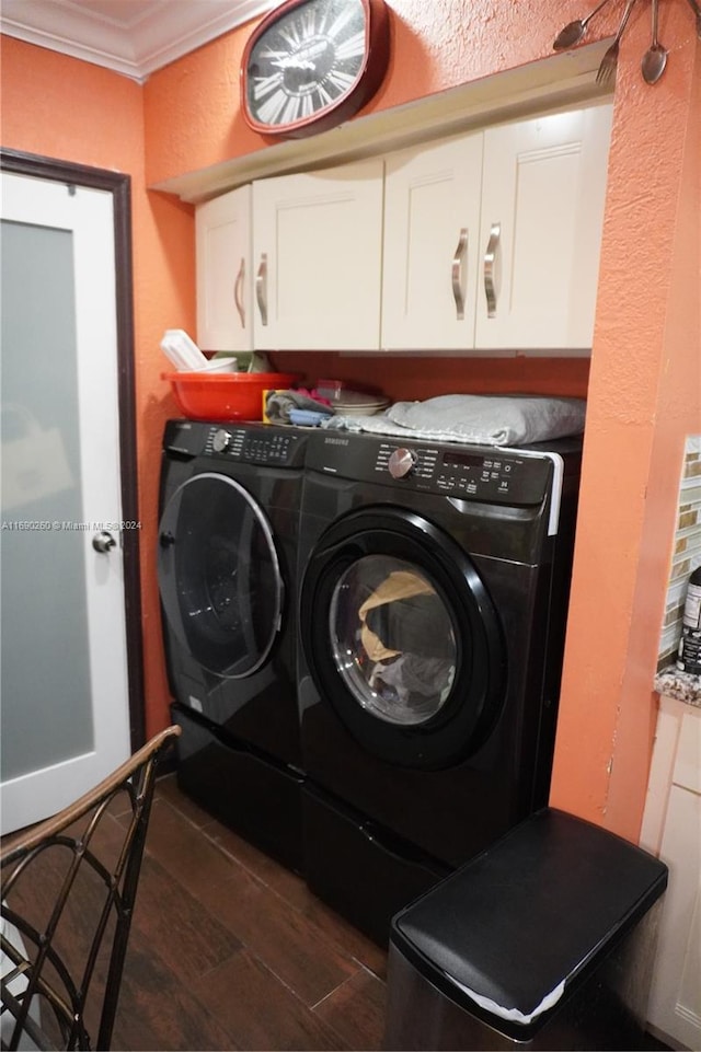 laundry area with cabinets, washer and clothes dryer, dark wood-type flooring, and ornamental molding