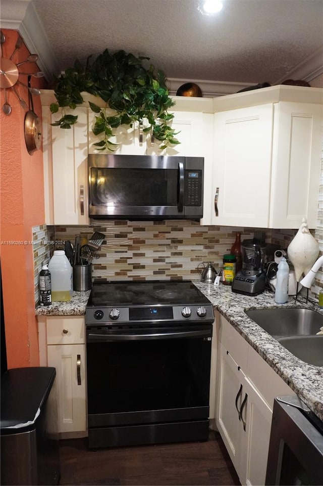 kitchen featuring crown molding, black stove, white cabinets, and sink