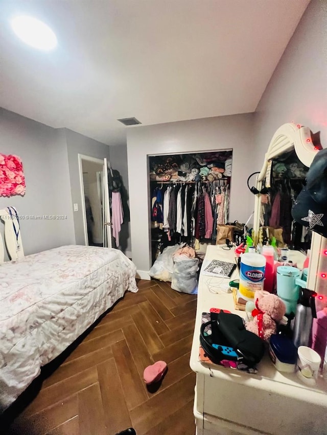 bedroom with a closet and dark parquet flooring