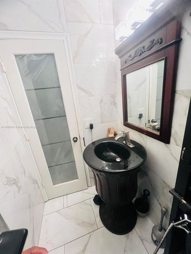 bathroom with vanity and tile walls