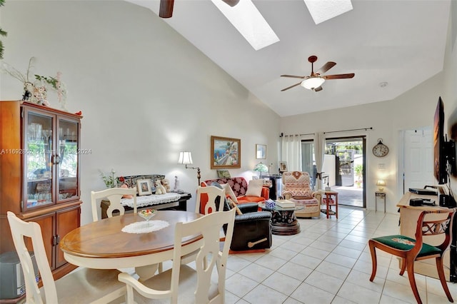 dining room featuring light tile patterned flooring, ceiling fan, a skylight, and high vaulted ceiling