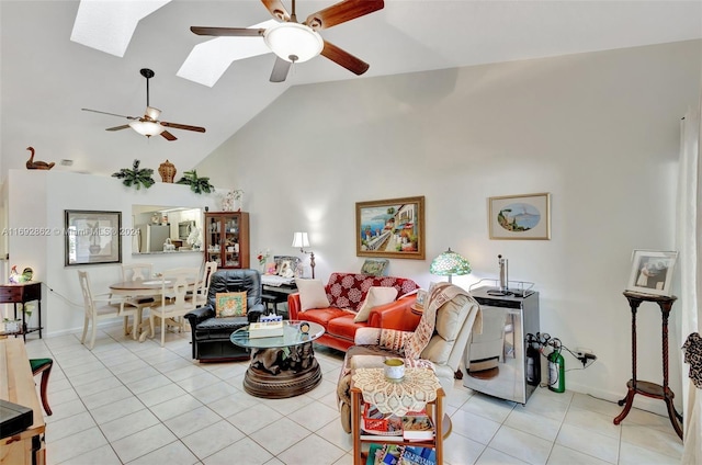 living room featuring light tile patterned floors, a skylight, high vaulted ceiling, and ceiling fan