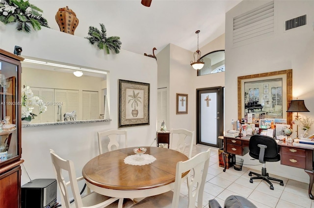 tiled dining space featuring high vaulted ceiling