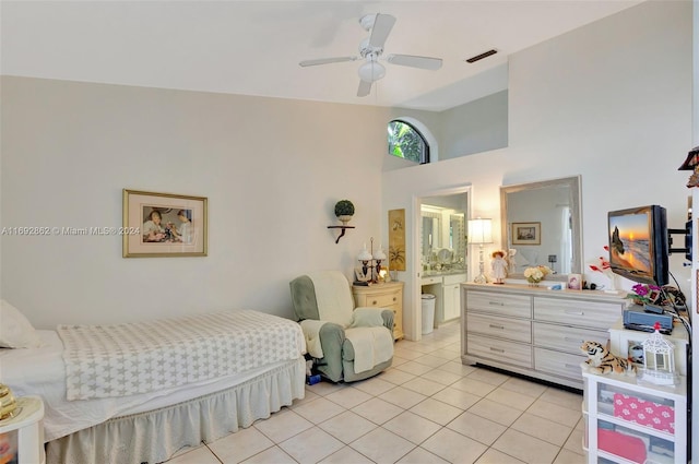 tiled bedroom featuring ceiling fan, connected bathroom, and a towering ceiling