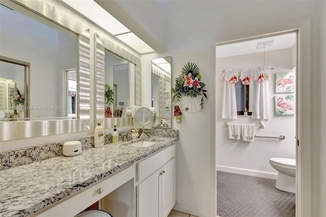 bathroom featuring toilet, tile patterned flooring, and vanity