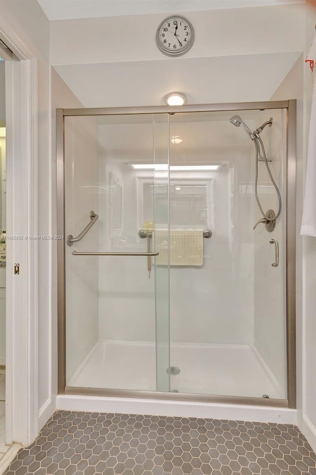 bathroom featuring an enclosed shower and tile patterned flooring