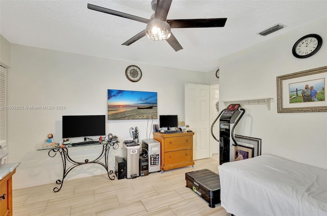 bedroom with ceiling fan and a textured ceiling