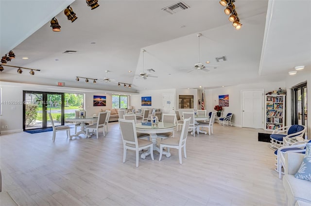 dining space featuring ceiling fan, vaulted ceiling, and light hardwood / wood-style flooring