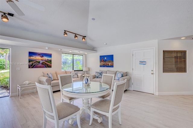 dining area featuring vaulted ceiling, ceiling fan, a textured ceiling, and light wood-type flooring