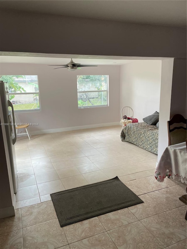 workout area with ceiling fan, plenty of natural light, and light tile patterned floors