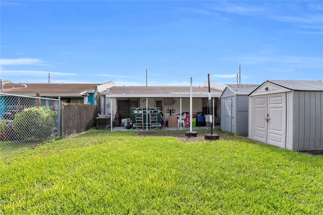 back of house featuring a storage unit and a lawn