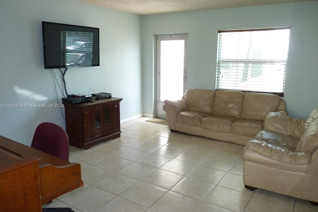 living room with light tile patterned flooring and a textured ceiling