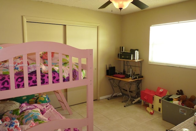 bedroom with a closet, ceiling fan, and light tile patterned flooring