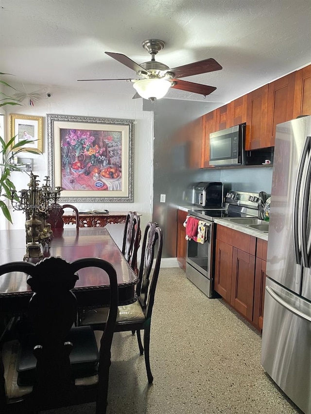 kitchen with ceiling fan, a textured ceiling, and appliances with stainless steel finishes