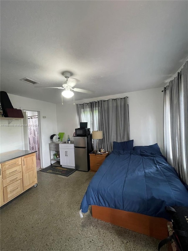 bedroom with stainless steel fridge and ceiling fan