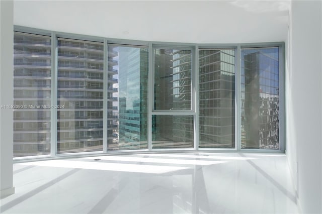 empty room featuring plenty of natural light and tile patterned flooring