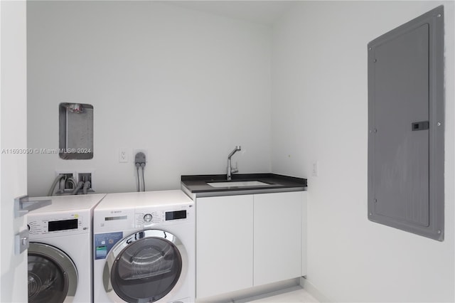 laundry area with cabinets, electric panel, separate washer and dryer, and sink