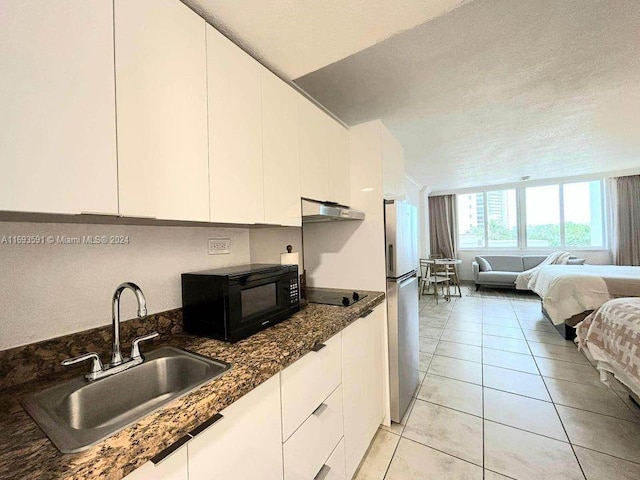 kitchen featuring black appliances, white cabinetry, sink, and extractor fan