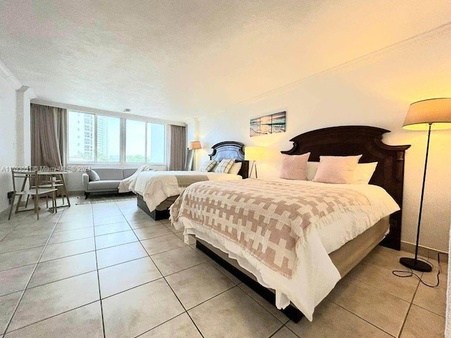 bedroom with tile patterned flooring, ornamental molding, and a textured ceiling