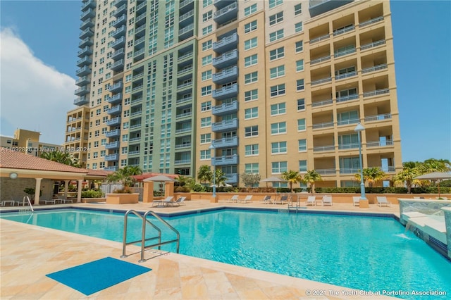 view of swimming pool with pool water feature and a patio