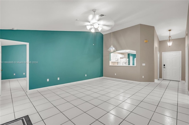 tiled spare room featuring ceiling fan and vaulted ceiling