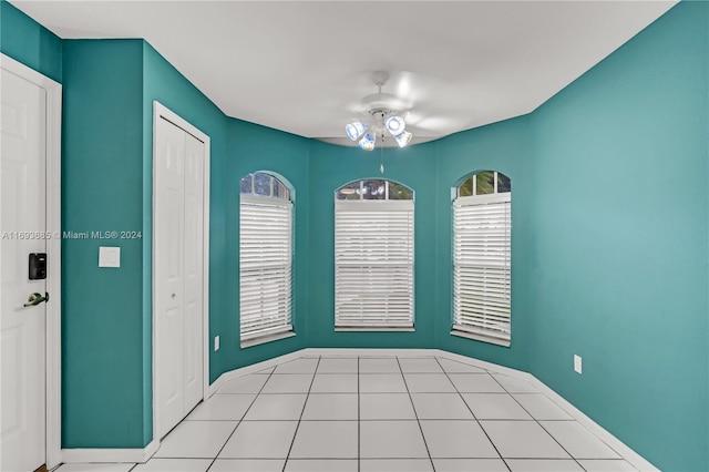 tiled empty room featuring ceiling fan