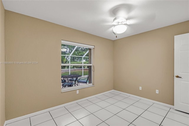 tiled spare room featuring ceiling fan