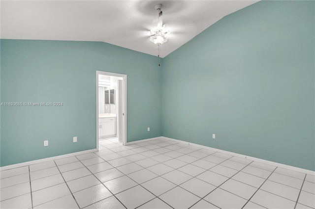 tiled empty room with ceiling fan and vaulted ceiling