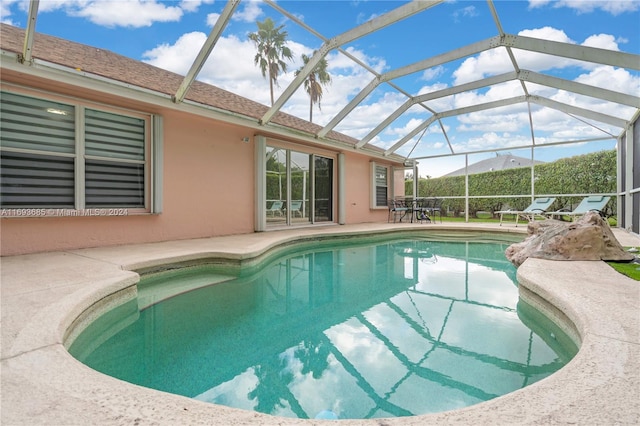 view of pool with a patio area and a lanai