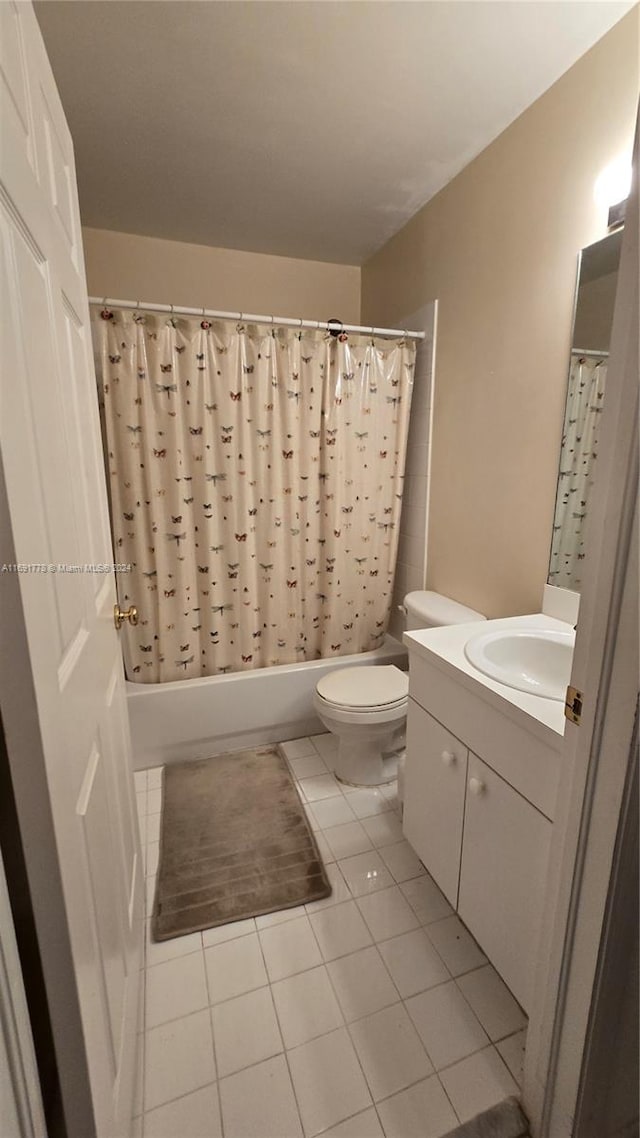 full bathroom featuring tile patterned floors, vanity, toilet, and shower / bath combo with shower curtain