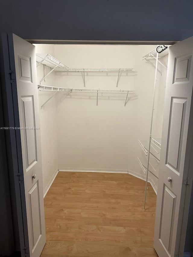 spacious closet with light hardwood / wood-style flooring