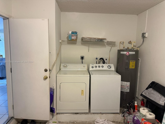 laundry room with water heater, light tile patterned floors, a textured ceiling, and independent washer and dryer